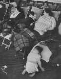 Ile de France. Tuckered out, a small survivor sleeps on its knees as the mother and two other children rest. Photo: Loomis Dean