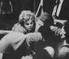 Still writing in terror, a girl survivor is taken onboard the Ile de France and comforted by rescuers. Man (left rear) shed his soaked clothes. (Photo:Loomis Dean)